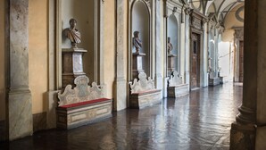 A corridor with classical architecture, featuring columns, arches, and busts on pedestals. - Residenza Napoleone III (Rome)