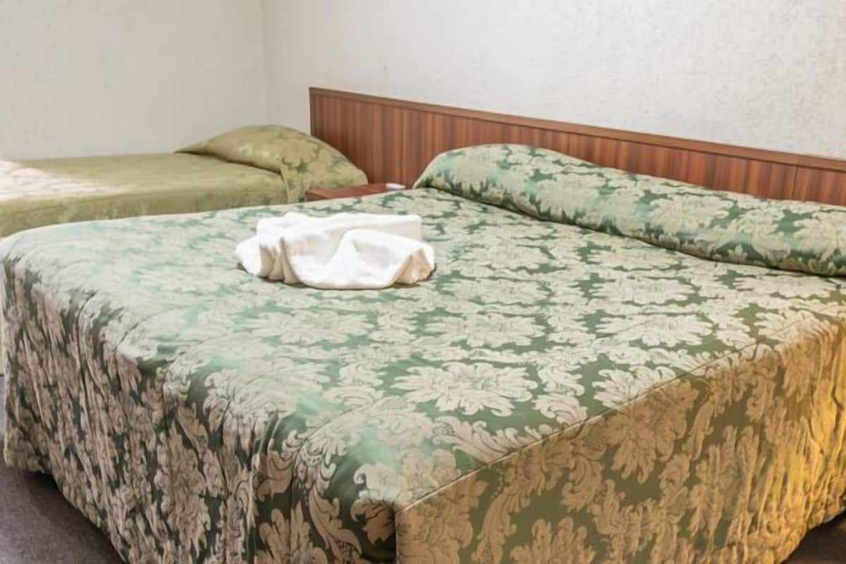 A room with a bed, a bedside table, and a lamp.