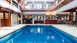 Ein großer, überdachter Pool mit Bar und Sitzgelegenheiten.