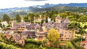 A large, castle-like building with multiple towers and a well-maintained garden. - Hotel Castelo Nacional Inn Campos do Jordão (Campos do Jordão)