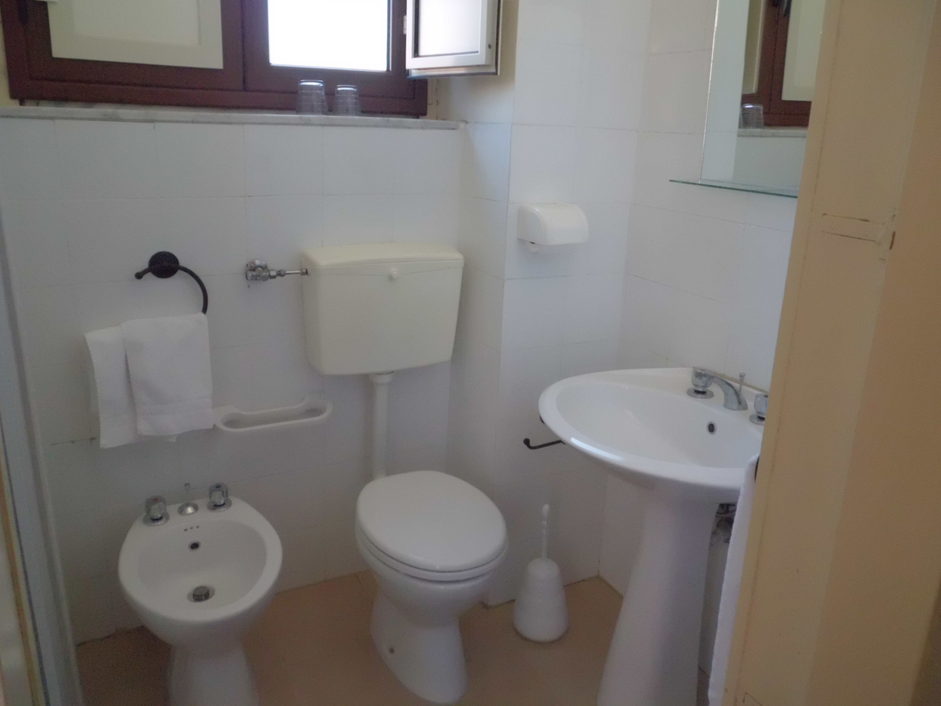A small bathroom with a toilet, bidet, and sink.