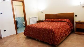 A bedroom with a bed, bedside table, and a nightstand.