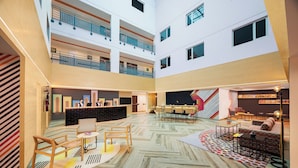 A spacious atrium with a reception desk, seating area, and a high ceiling with balconies. - Ginger Jaipur (Jaipur)