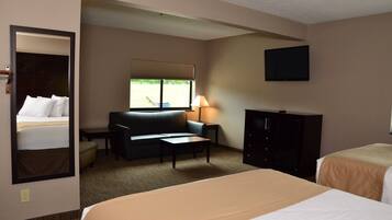 Une chambre d’hôtel équipée d’un lit, d’un canapé, d’un bureau, d’une lampe, d’une télévision et d’une armoire.