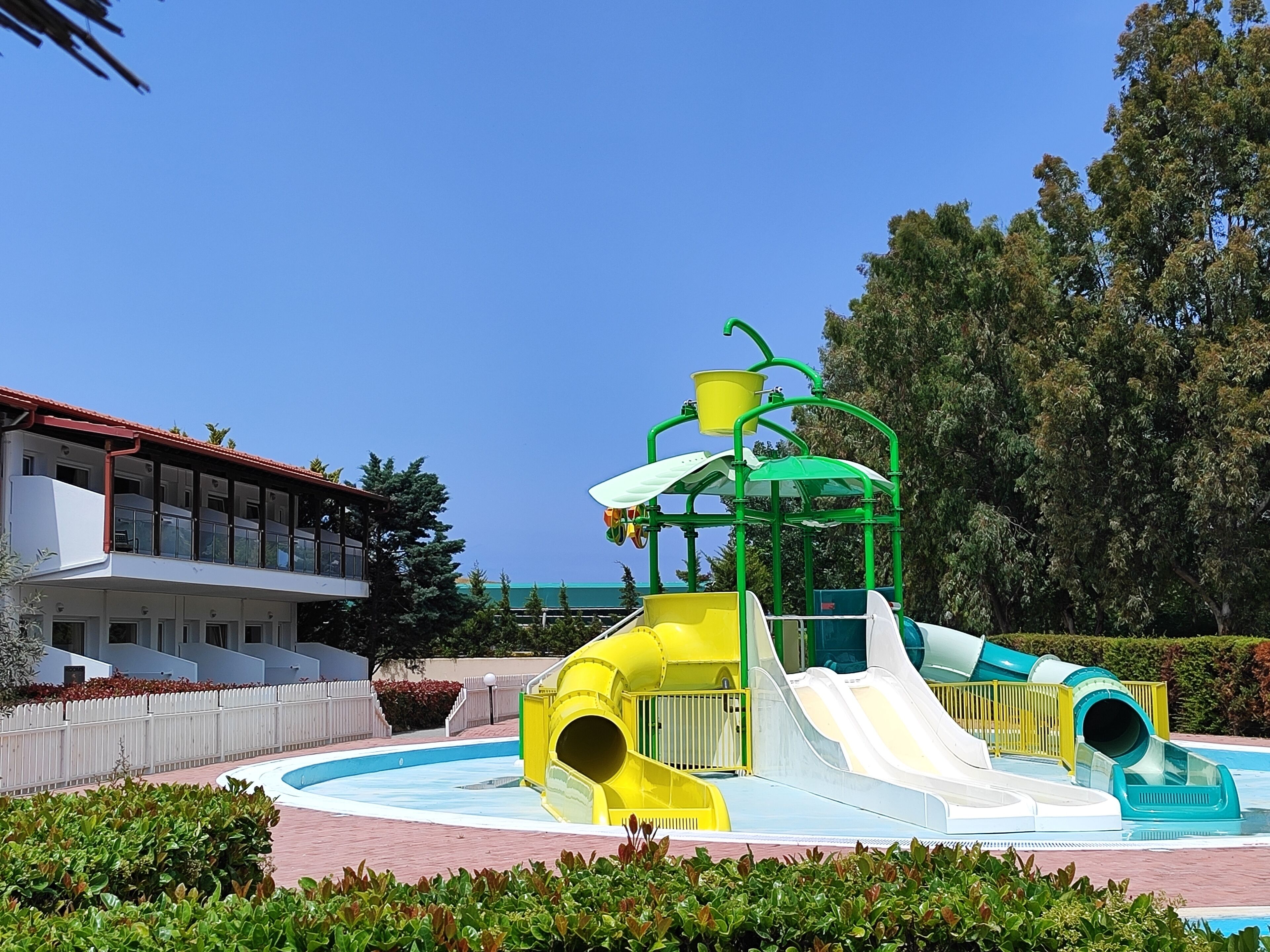 Ein Wasserpark mit mehreren Rutschen und einer Spielkonstruktion in Grün.
