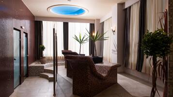 Un hall d’entrée moderne avec une verrière, un espace salon, des plantes en pot et un comptoir d’accueil.