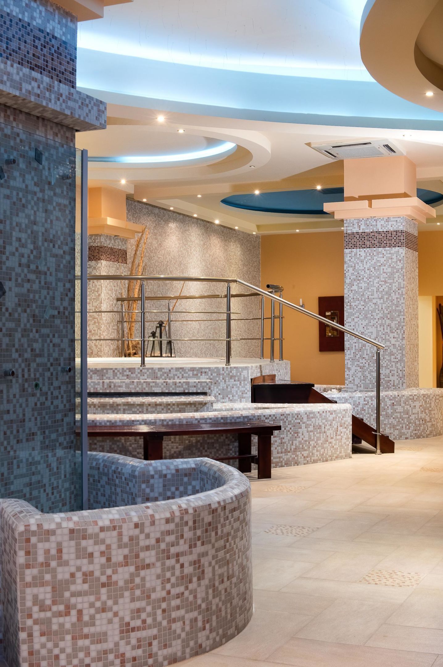 Um lobby moderno com piso ladrilhado, escada e área de estar.