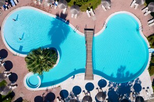 Una piscina al aire libre de temporada, sombrillas