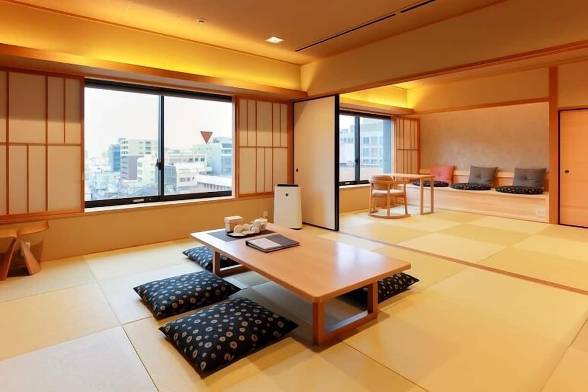 A traditional Japanese room with tatami flooring, a low table with cushions, and sliding doors.