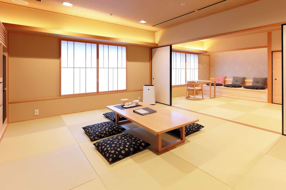 A traditional Japanese room with tatami flooring, a low wooden table, and a sliding door.