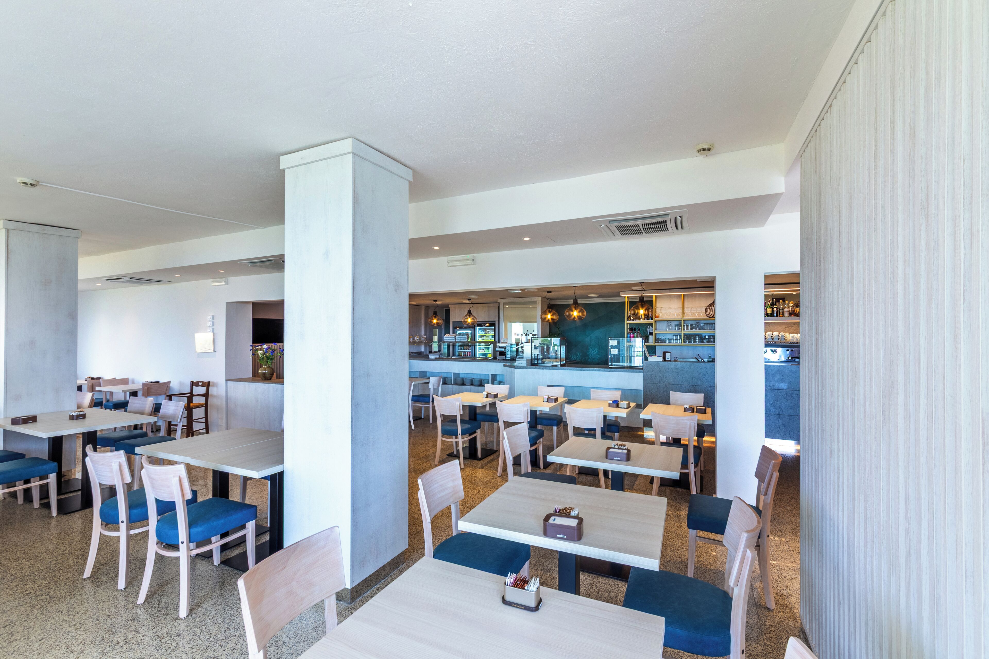 A modern restaurant with multiple seating areas, including booths and tables.