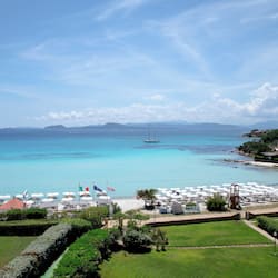 Praia particular, areia branca, espreguiçadeiras, guarda-sóis