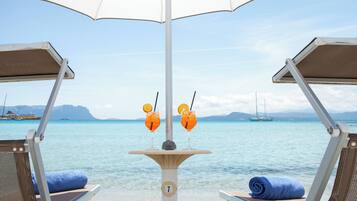 Privatstrand, weiĂer Sandstrand, LiegestĂŒhle, Sonnenschirme