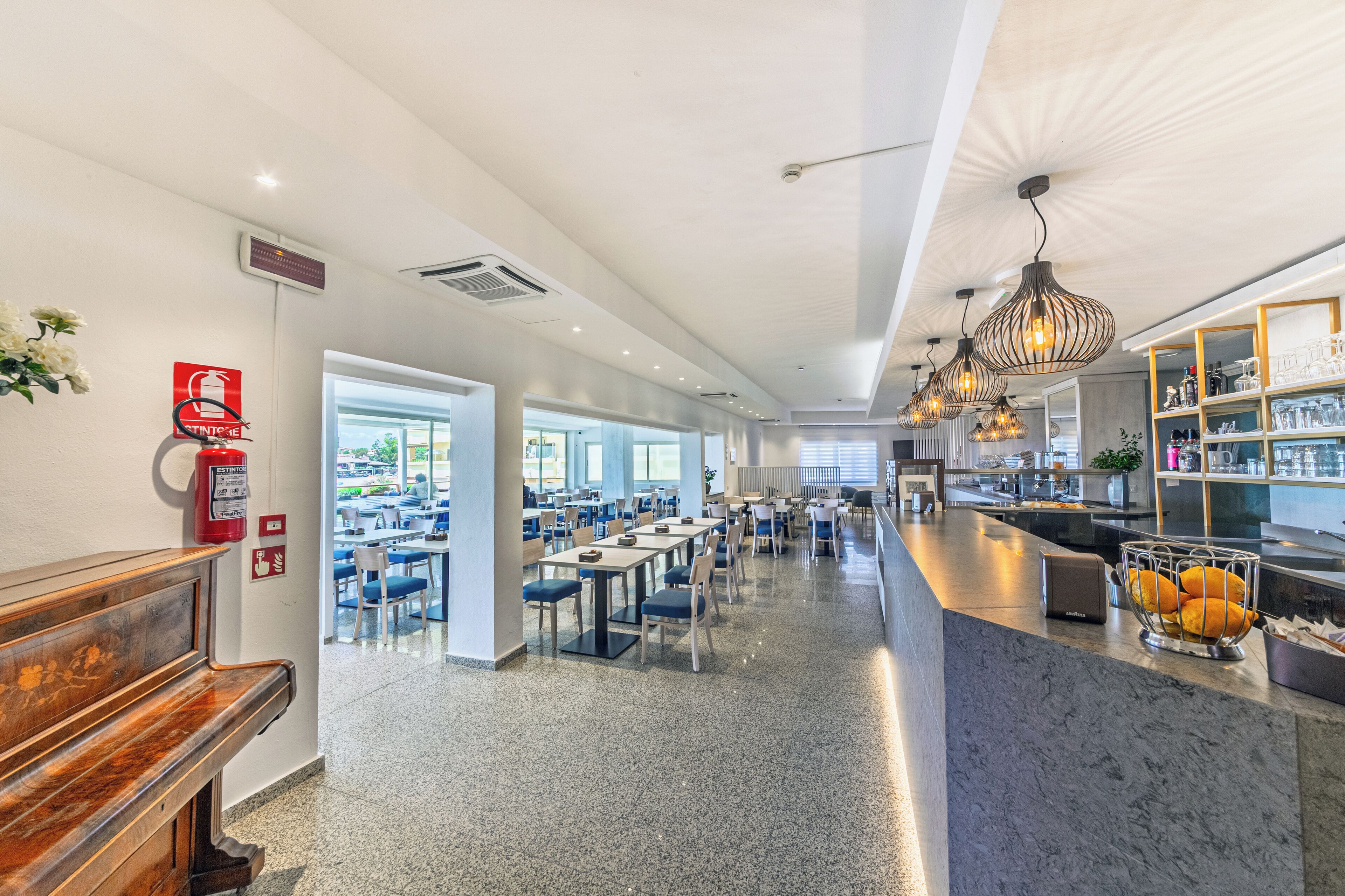 A spacious cafeteria with high ceilings, modern lighting, and a central serving area.