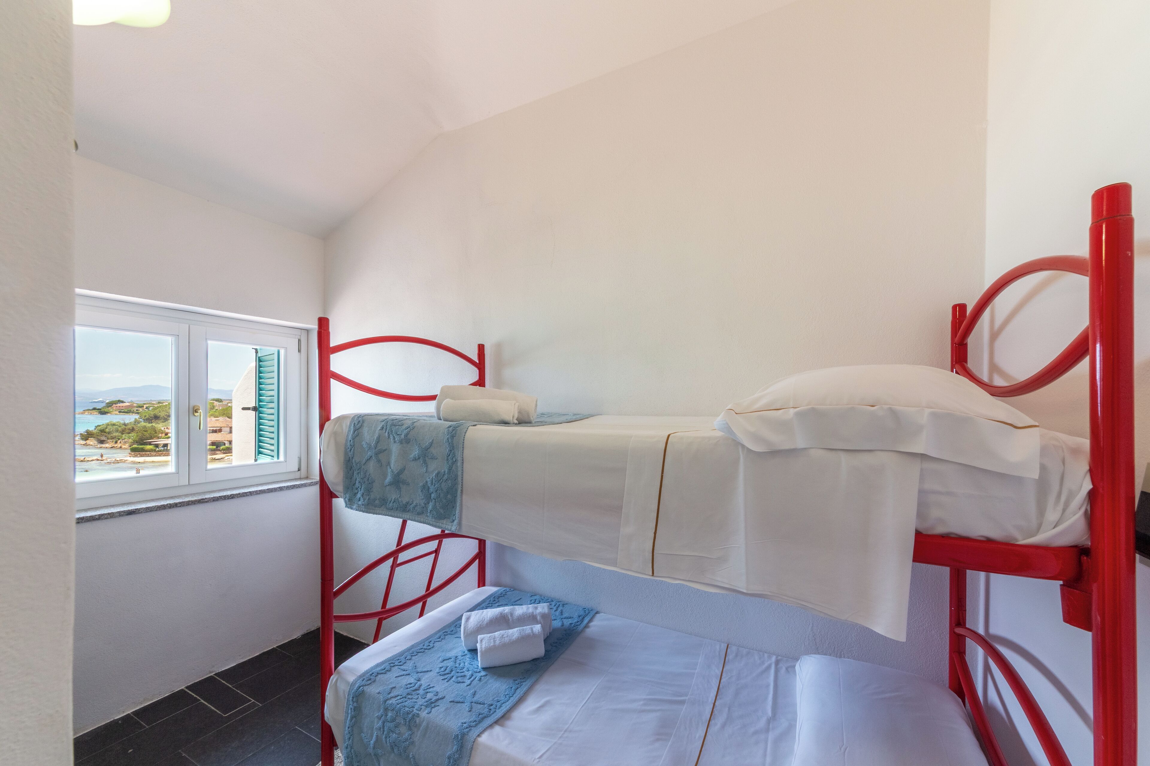 A bunk bed room with a window overlooking a scenic view.