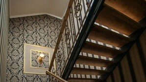 A staircase with ornate metal railings and a patterned wall. - Hotel Litera (Dnipro)