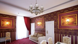 A room with a red carpet, white furniture, and patterned wallpaper. - Hotel Litera (Dnipro)