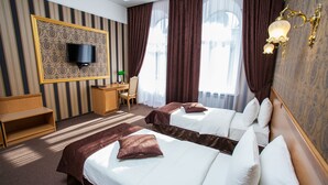 A hotel room with two beds, a TV mounted on the wall, a desk, and a chair. - Hotel Litera (Dnipro)