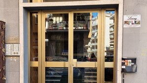 A building entrance with a large glass door and a sign advertising 'Bed and Breakfast Living'. - B&B Living (Rome)