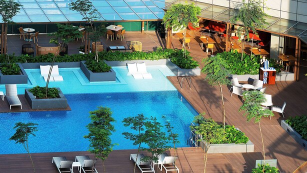 Área de piscina en la azotea con sillones, una piscina pequeña y abundante vegetación.