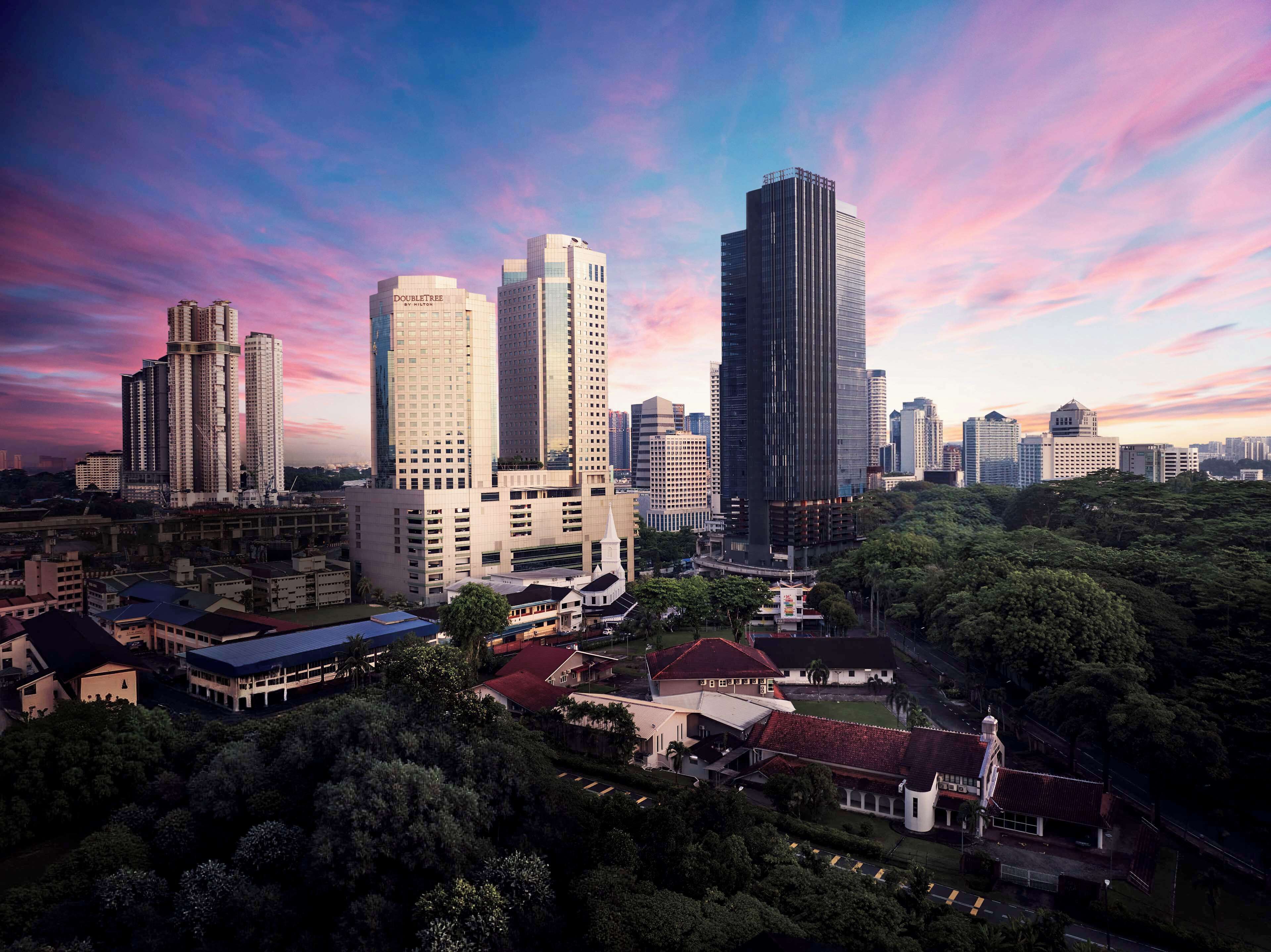 Paesaggio urbano con moderni grattacieli e un mix di edifici residenziali e commerciali.