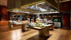 Una cocina moderna con electrodomésticos de acero inoxidable, encimeras de madera y una mesa de buffet.