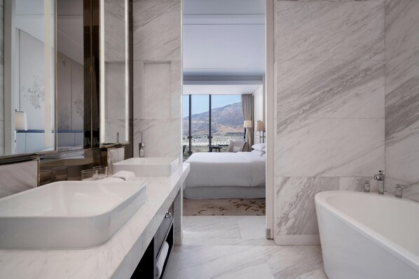Un baño moderno con una bañera grande, un tocador doble y un espejo amplio.