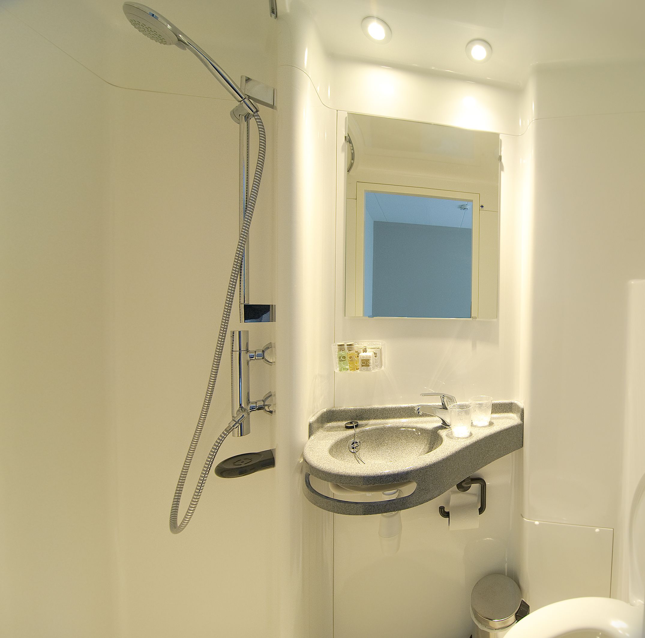 A bathroom with a shower, sink, and toilet.