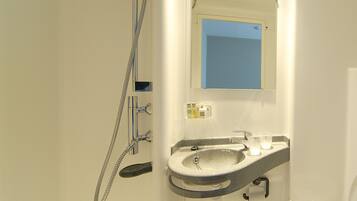 A bathroom with a shower, sink, and toilet.