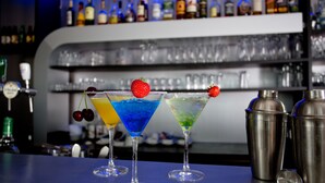 Three martini glasses with colorful drinks and cherries on a bar counter. - Best Western Plus Hotel Restaurant Aduard (Aduard)