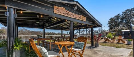 An outdoor seating area with wooden furniture and a sign reading "Suwannee River".