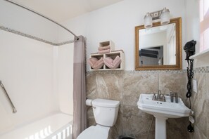 A bathroom with a shower, toilet, sink, and a mirror with lights. - Suwannee Gables Motel and Marina (Old Town)