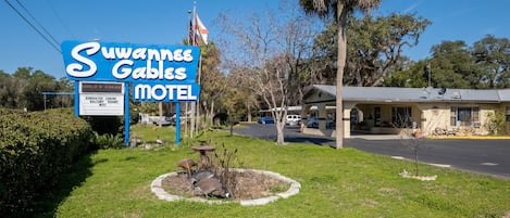 A motel named 'Suwannee Gables' with a signboard, renovated cabins, balcony rooms, and WIFI.