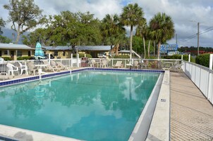 Una piscina al aire libre, sombrillas, tumbonas