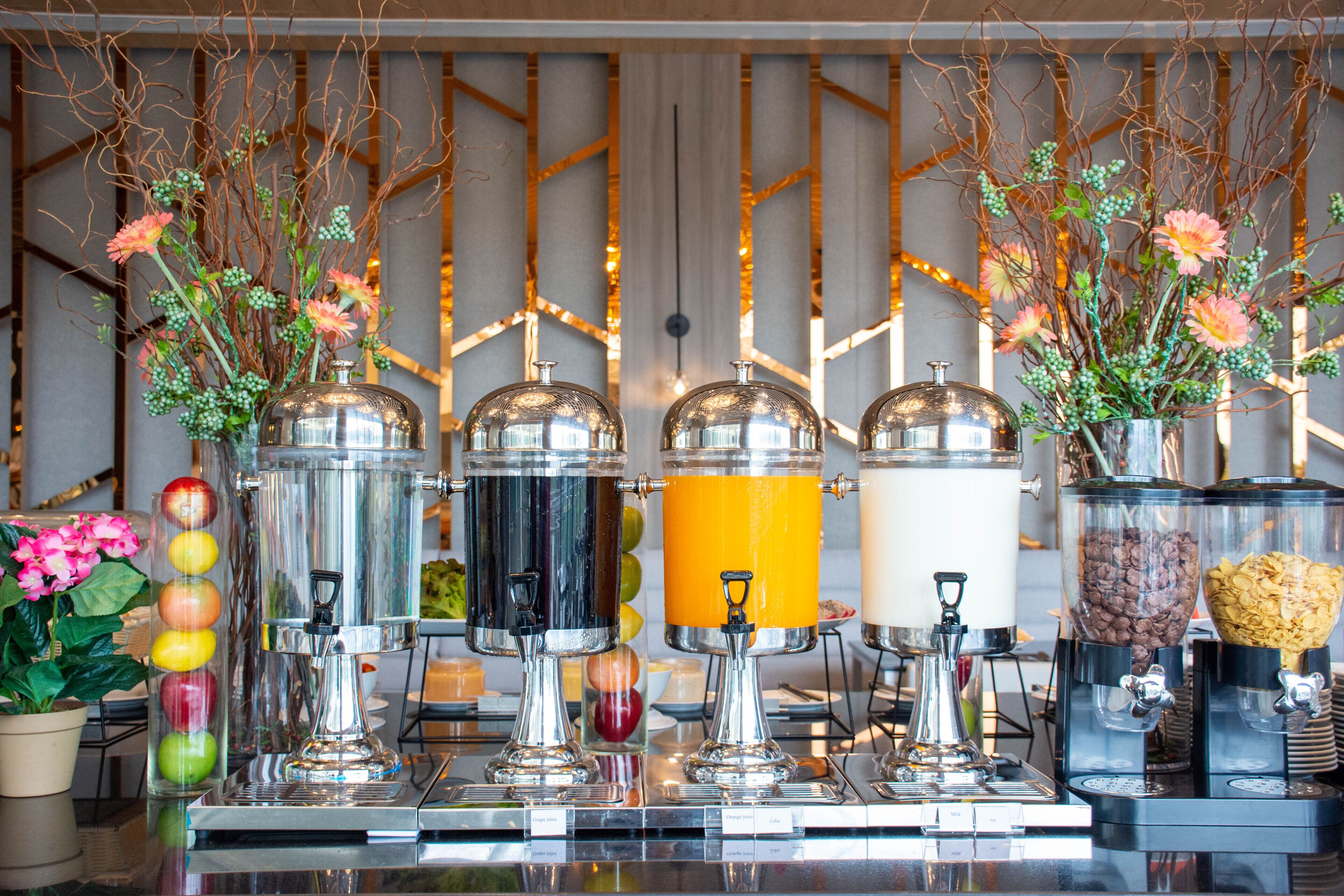 A beverage station with multiple dispensers, including apple juice, orange juice, and coffee.