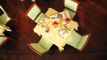 Zona pranzo con tavolo apparecchiato per quattro, circondato da sedie.