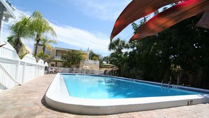 A rectangular pool with a white edge, surrounded by a brick patio. - Venice Beach Villas (Venice)