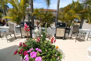 An outdoor patio area with seating and barbecue grills.
