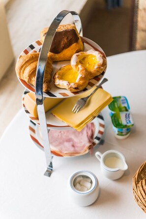 A breakfast setup with croissants, ham, butter, and a jug of milk on a table. - B&B Villa De Keyser (Eeklo)