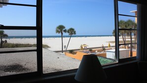 A beach view from a window with a lamp on the windowsill. - iBeach Resort (Treasure Island)