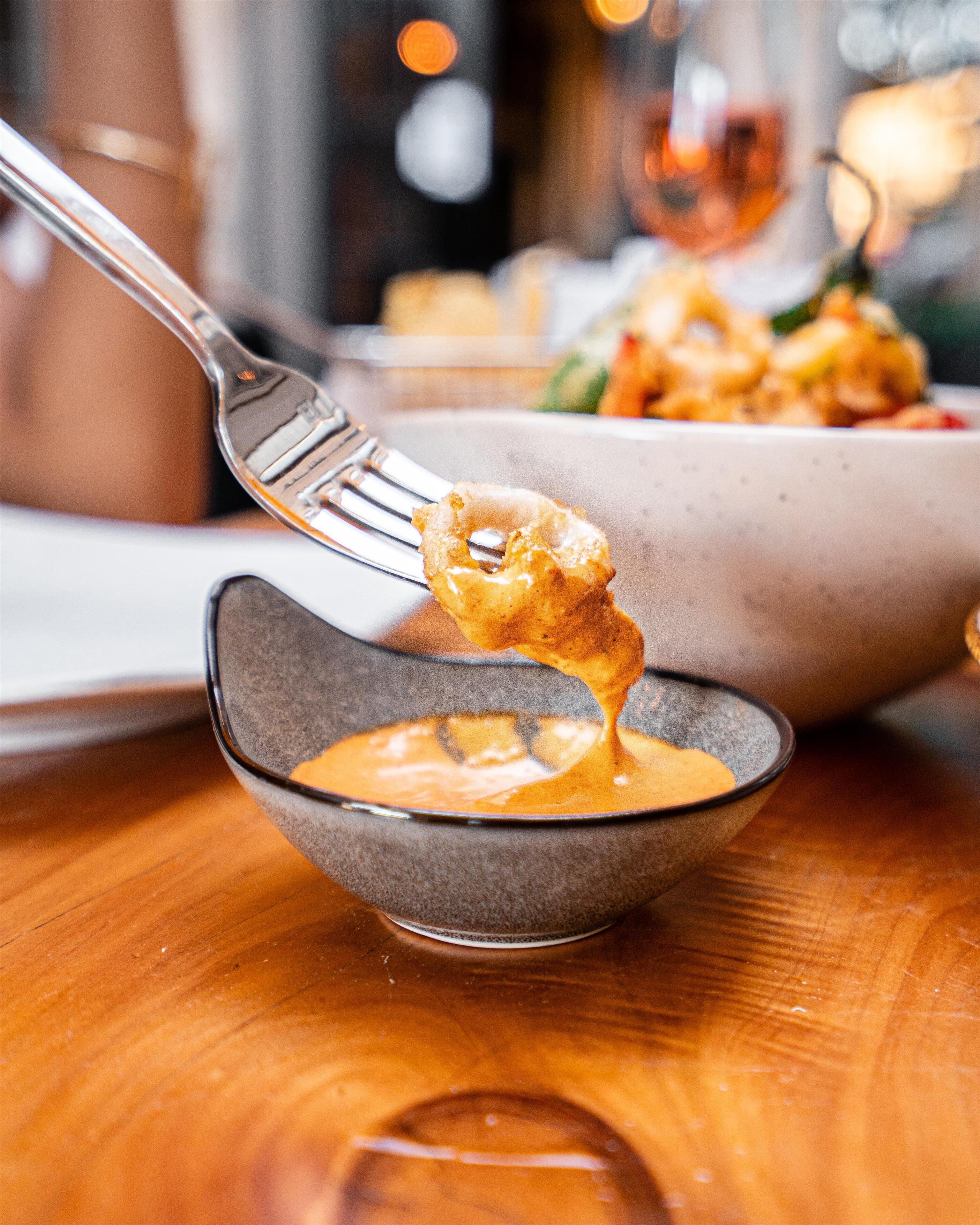 Un tazón de sopa con una cuchara levantando un bocado.