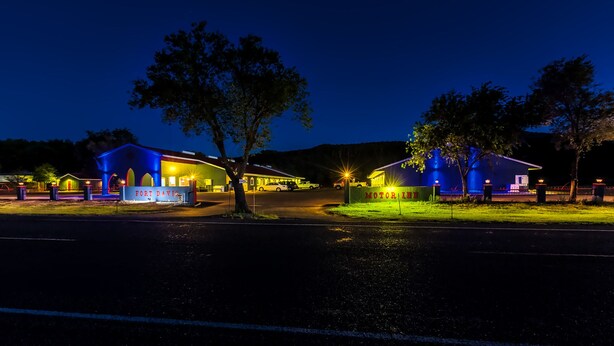 A motel with a sign reading "FORT DAVIS MOTOR HOME" at night.