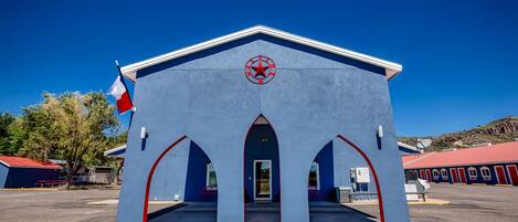 A building with a red star logo, a flag, and a red roof.