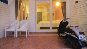 A room with a bed, a scooter, and two white chairs. - Boutique Guesthouse by Clearhouse (Kamala)