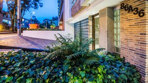 A modern building with a brick facade, a glass door entrance, and a number sign '86A36'. - Viaggio Virrey (Bogotá)