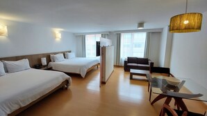 A hotel room with two beds, a sofa, a dining table, and a TV. - Viaggio Virrey (Bogotá)