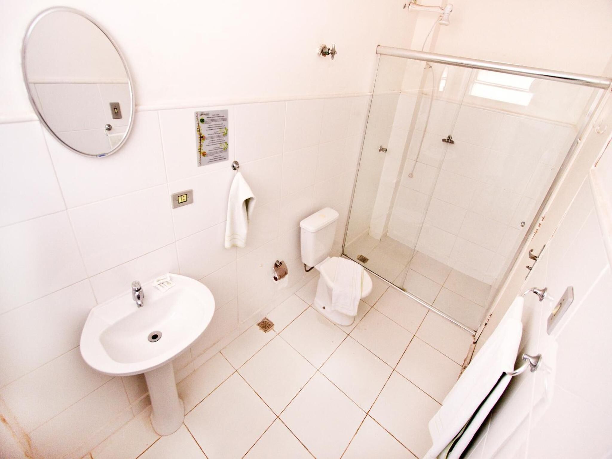 A bathroom with a sink, toilet, and glass shower enclosure.