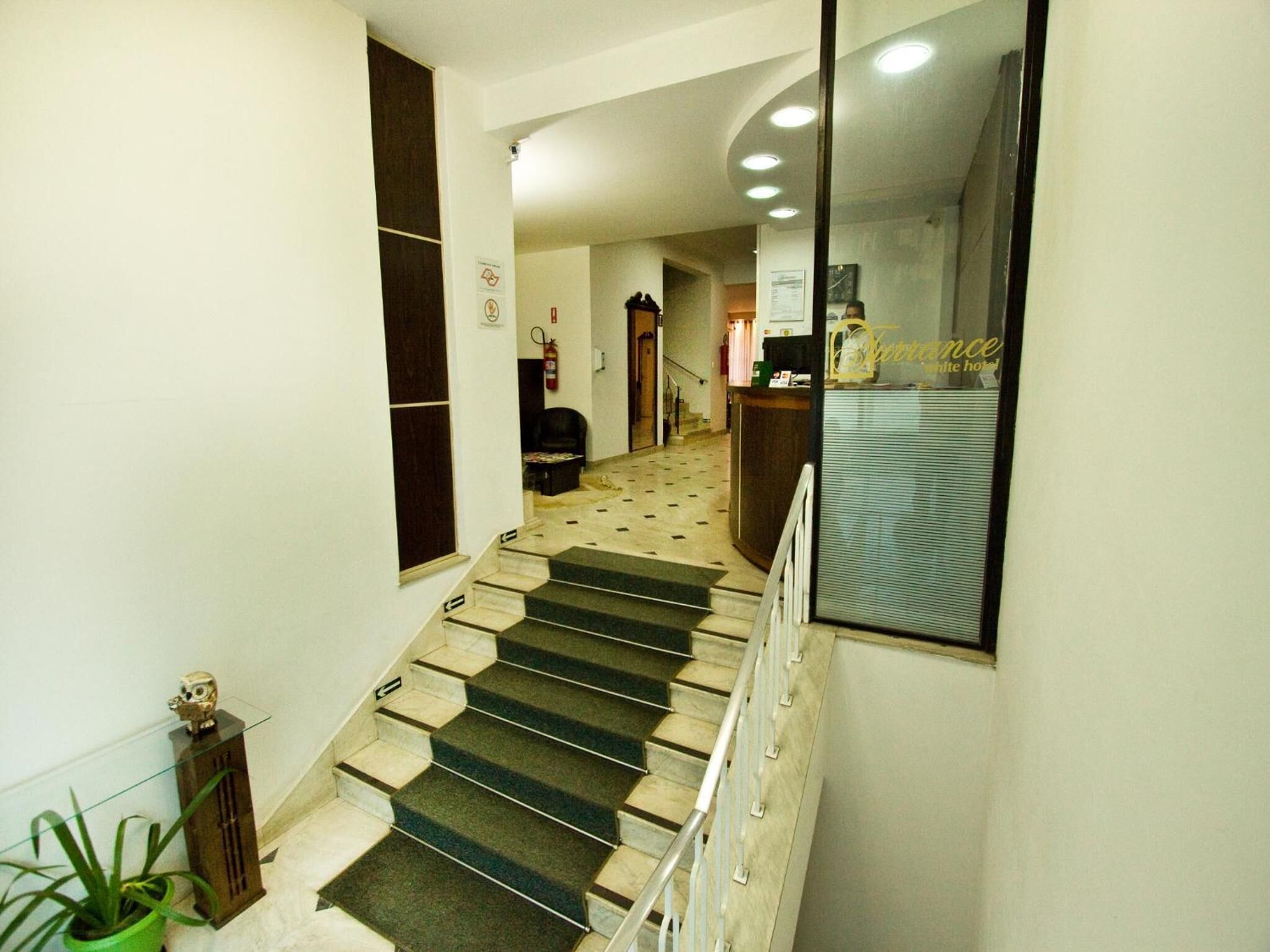 A hotel hallway with a staircase leading to a reception area.