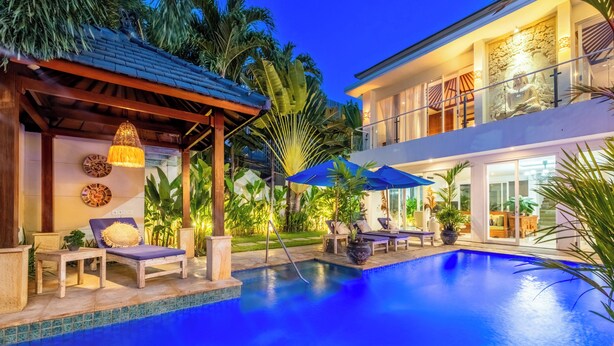 A poolside area with lounge chairs, umbrellas, and a clear blue pool. - AQ-VA Hotel & Villas Seminyak (Legian)