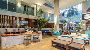 A spacious lobby with a reception desk, seating areas, and a coffee bar. - AQ-VA Hotel & Villas Seminyak (Legian)